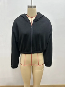 Detail eines schwarzen Cropped-Kapuzenpullovers mit Reißverschluss, Gummibund und Drop-Shoulder