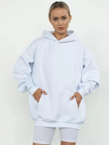 Detail of light blue oversized hoodie featuring a front kangaroo pocket and ribbed cuffs