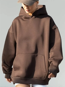 Detail of oversized dark brown hoodie with drop shoulders and kangaroo pocket design
