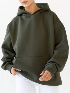 Detailed view of dark green oversize hoodie featuring a front pocket and ribbed cuffs