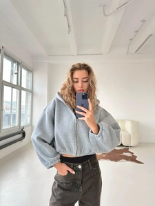 Details des grauen Zip-Hoodies mit überschnittenen Schultern und Bündchen