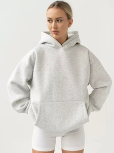 Detail of light gray oversized hoodie showing fabric texture and kangaroo pocket