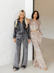 Detailed view of women's velvet tracksuit featuring zip-up jacket and wide-leg trousers