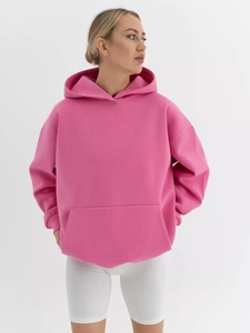 Detail of loose-fit pink hoodie with kangaroo pocket and drop shoulder seams