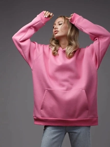 Detail of pink oversized hoodie showing ribbed cuffs and classic kangaroo pocket