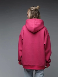 Detail of fuchsia oversized hoodie showing drop shoulder seams and ribbed knit cuffs