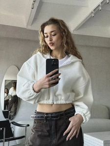 Nahaufnahme des weißen Crop-Zip-Hoodies mit elastischem Bund im lässigen Street-Style