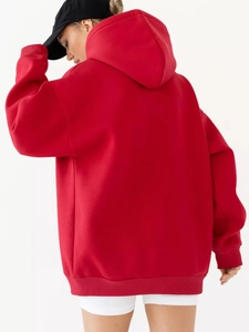 Detail of red oversized hoodie featuring ribbed cuffs and high-quality fleece fabric