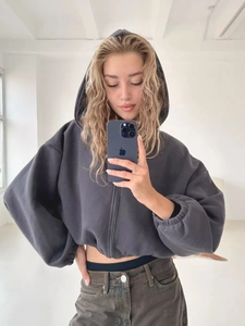 Detail eines dunkelgrauen Cropped-Hoodie mit Reißverschluss und gerippten Ärmelbündchen