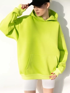 Detail view of neon yellow oversized hoodie with kangaroo pocket and ribbed cuffs