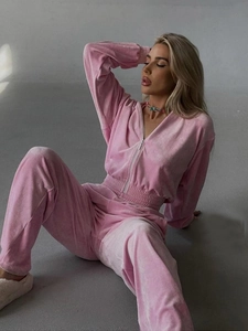 Detail of light pink velvet tracksuit featuring a cropped zip hoodie and matching joggers