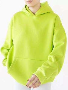 Macro shot of neon green oversized hoodie with kangaroo pocket and ribbed cuffs detail
