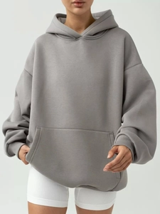 Detailed view of oversized grey hoodie with kangaroo pocket and ribbed sleeve cuffs