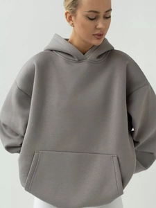 Detail of dark grey oversized hoodie featuring kangaroo pocket and premium heavy knit texture