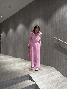 Detail of pink velvet two-piece tracksuit with zipper top and wide-leg trousers