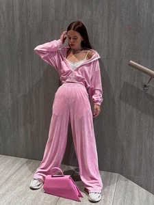 Detail of pink velvet two-piece set featuring a zip-up hoodie and high-waist trousers