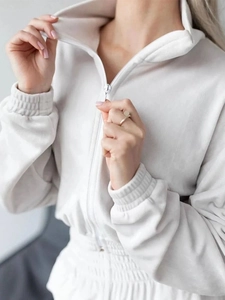Detail of off-white half-zip sweatshirt featuring a stand collar and textured fabric