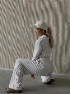 Detail of off-white velvet tracksuit with long sleeves and wide-leg trousers on a model