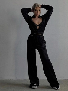 Detail of black two-piece lounge set with metallic waist chain and zip-up jacket