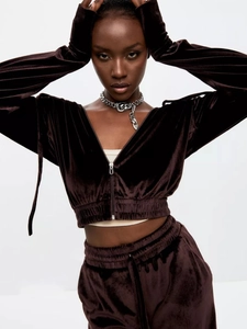 Detail of dark chocolate velvet two-piece set featuring cropped zip hoodie and elastic pants