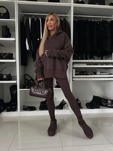 Detalle del conjunto de sudadera oversize marrón oscuro con leggings y botas