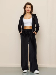 Detailed texture of black velvet tracksuit with zip-up hoodie and high-waist wide-leg pants