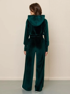 Detail view of the forest green velvet tracksuit showing high-quality fabric texture