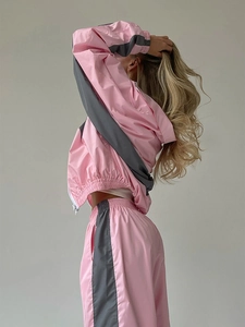 Dettaglio del set giacca con cappuccio e zip e pantaloni sportivi rosa e grigi