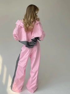 Vista posteriore di una tuta da donna a due pezzi rosa e grigia con giacca con cappuccio