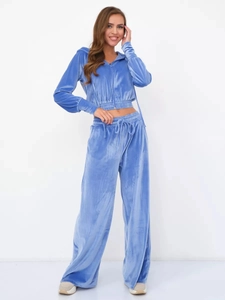 Detail of light blue velvet track suit featuring zip-up hoodie and wide-leg trousers