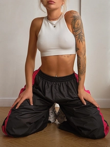 Dettaglio dei pantaloni sportivi a vita alta con strisce rosa e crop top