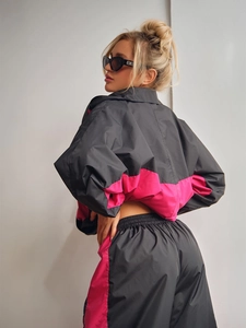 Dettaglio della tuta sportiva grigia e rosa con giacca con zip e pantaloni a righe laterali