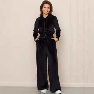 Women's black velvet tracksuit featuring a zip-up hooded jacket and wide-leg trousers