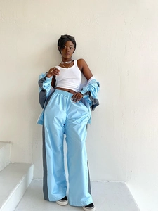 Dettaglio di una tuta sportiva bicolore azzurra e grigia con pantaloni a gamba larga