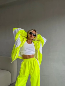 Dettaglio della tuta sportiva bicolore giallo neon e bianco con giacca e pantaloni