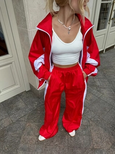 Dettaglio della tuta bicolore rossa e bianca con giacca zip e pantaloni sportivi larghi