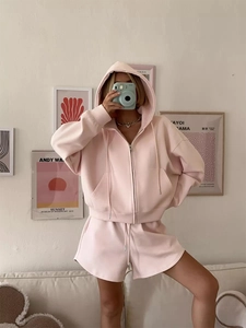 Detail view of pink zip-up hoodie set with drawstring shorts in a home lifestyle setting