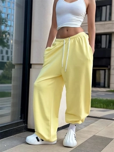 Dettaglio dei pantaloni larghi giallo chiaro con coulisse in vita e stile street urbano