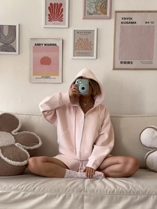 Close-up of light pink hoodie and shorts set made of soft jersey fabric in a cozy setting