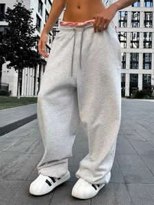 Dettaglio di pantaloni joggers grigio chiaro a gamba larga con coulisse e vestibilità comoda