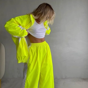 Tuta sportiva bicolore giallo neon e bianco con giacca a zip e pantaloni sportivi larghi