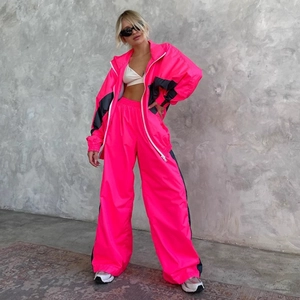 Tuta neon rosa con giacca a vento e pantaloni larghi coordinati in stile sportivo