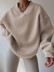 Detailed close-up of oatmeal V-neck oversized sweatshirt with ribbed cuffs and drop shoulder