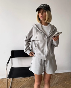 Detail of grey hooded zip-up sweatshirt and drawstring shorts lounge set with side pockets