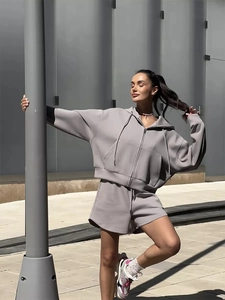 Detail of lilac two-piece tracksuit featuring a zip-up hoodie and loose-fit matching shorts