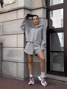 Detail shot of a grey hooded zip-up sweatshirt and drawstring shorts lounge set