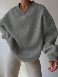 Detail showing the deep V-neckline and ribbed texture of a grey long sleeve sweatshirt