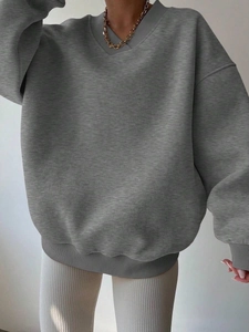 Detail of grey oversized V-neck sweatshirt featuring premium rib knit texture