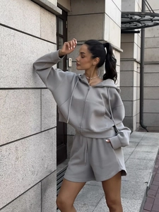 Detail of light gray two-piece set featuring cropped zip-up hoodie and high-waist shorts