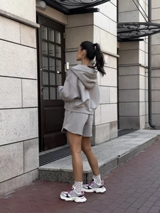 Detail of grey hooded sweatshirt and matching shorts set in a street lifestyle setting